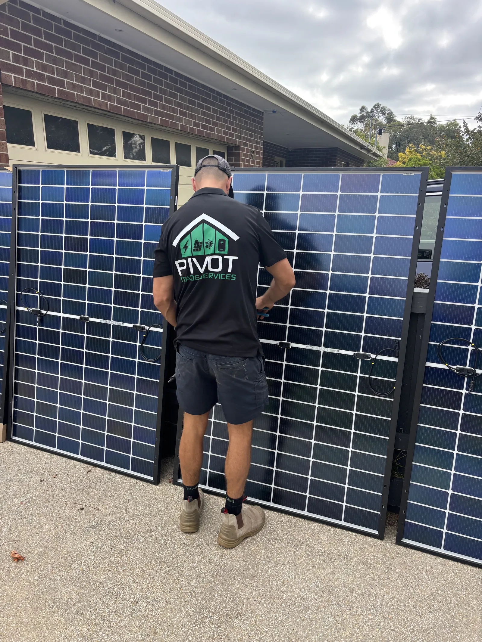 Dan Morgan preparing solar panels stood against a fence before they go on the roof