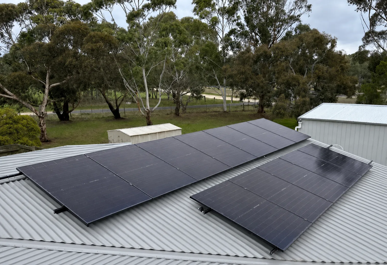 Two rows of solar panels laid out across a corrugated colorbond roof